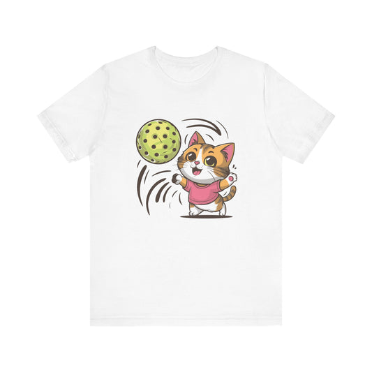 T-shirt in an alternate color showcasing the same adorable cartoon cat in a pink shirt playing with a pickleball.