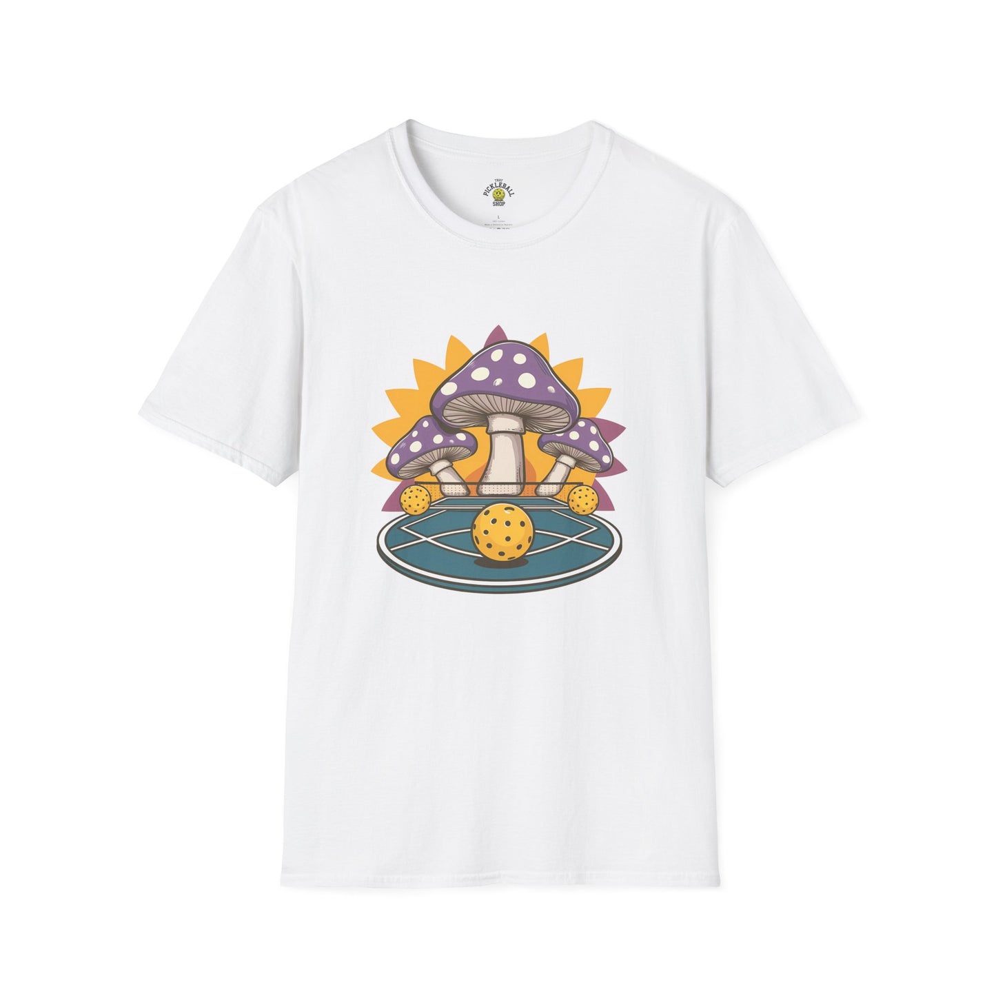 White t-shirt featuring a whimsical design of purple mushrooms surrounding a pickleball on a circular court with a bright yellow sunburst in the background.