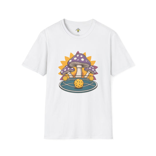 White t-shirt featuring a whimsical design of purple mushrooms surrounding a pickleball on a circular court with a bright yellow sunburst in the background.